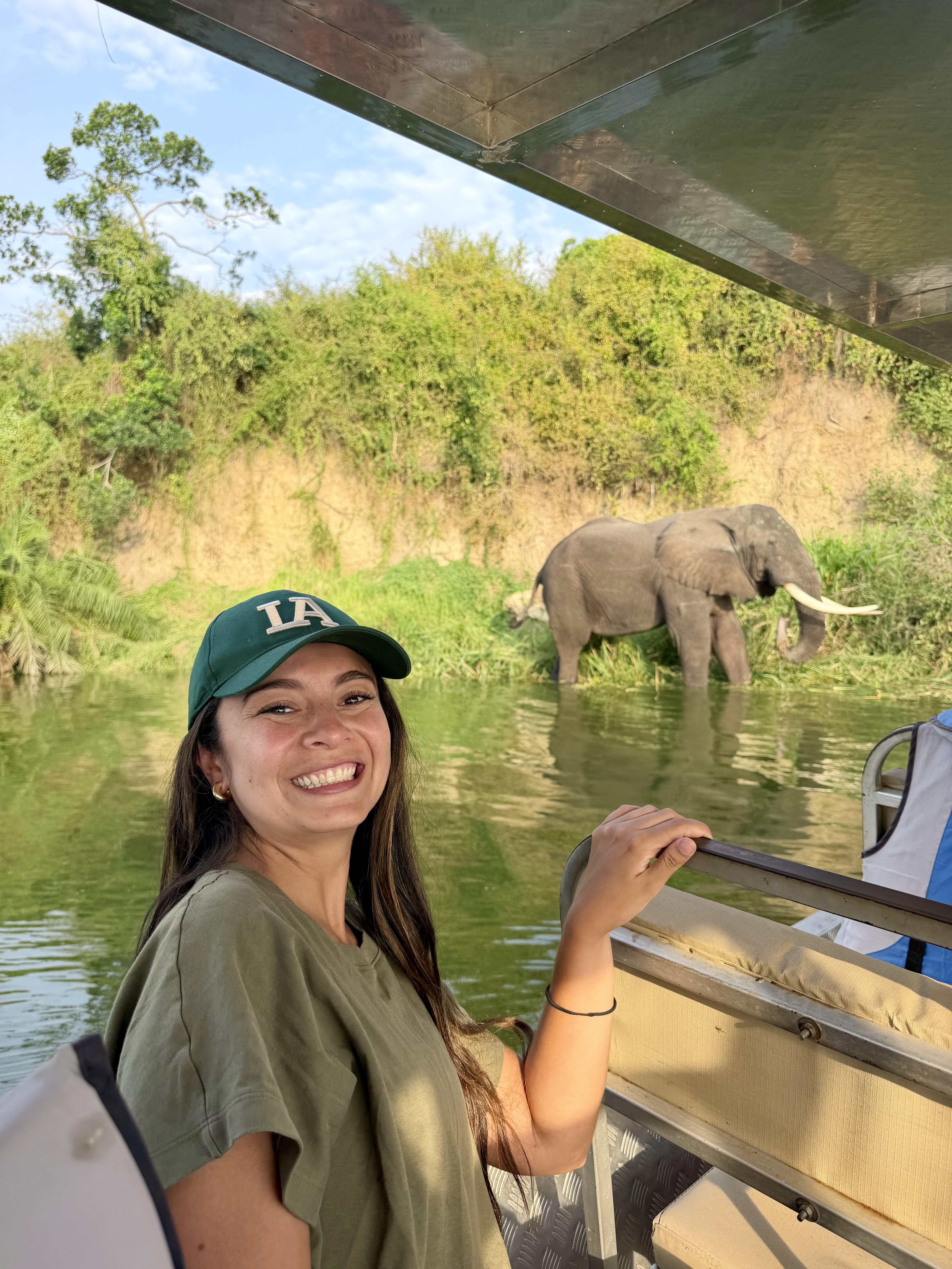 Viajera en barco por el Nilo con un elefante africano en la orilla, Uganda