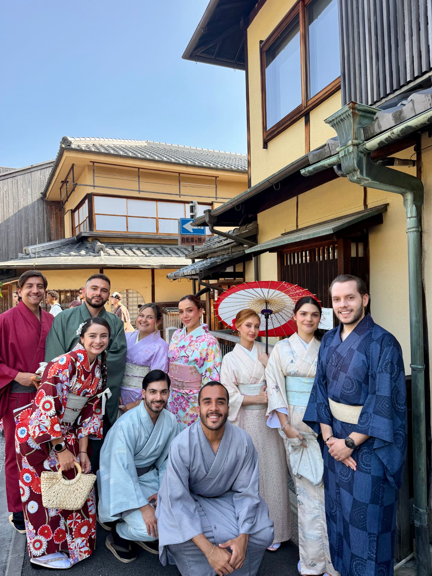 Grupo de viajeros en kimono con paraguas rojo en Kioto