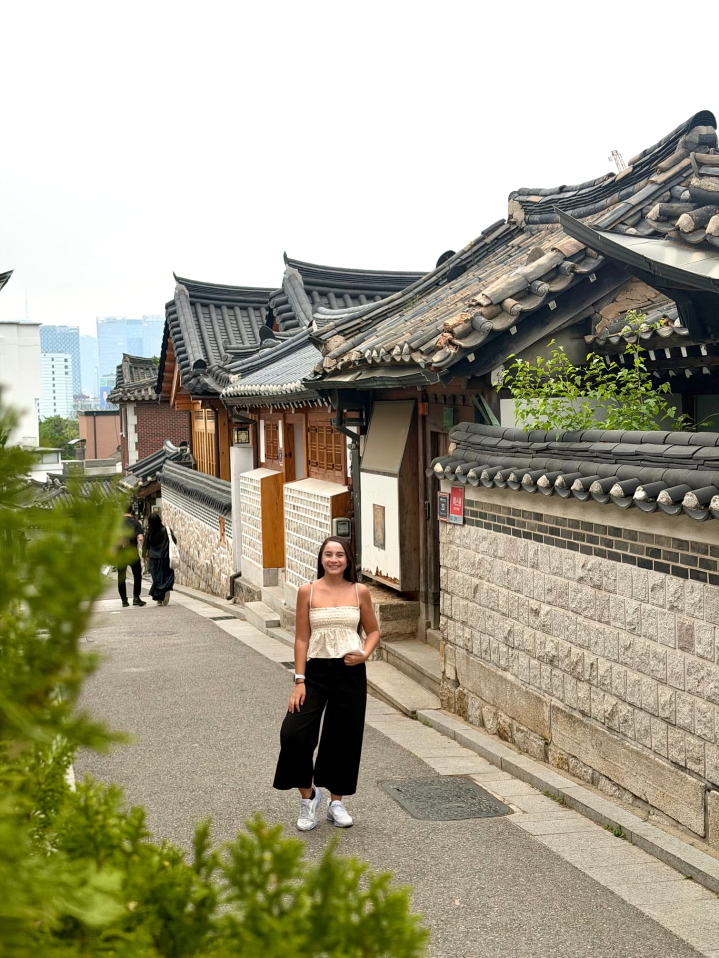 Viajera sonriendo en una calle de Bukchon Hanok Village en Seúl