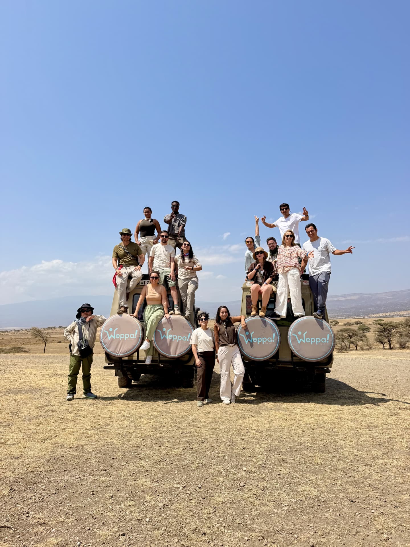 Grupo Weppa posando sobre los jeeps safari en la sabana de Tanzania