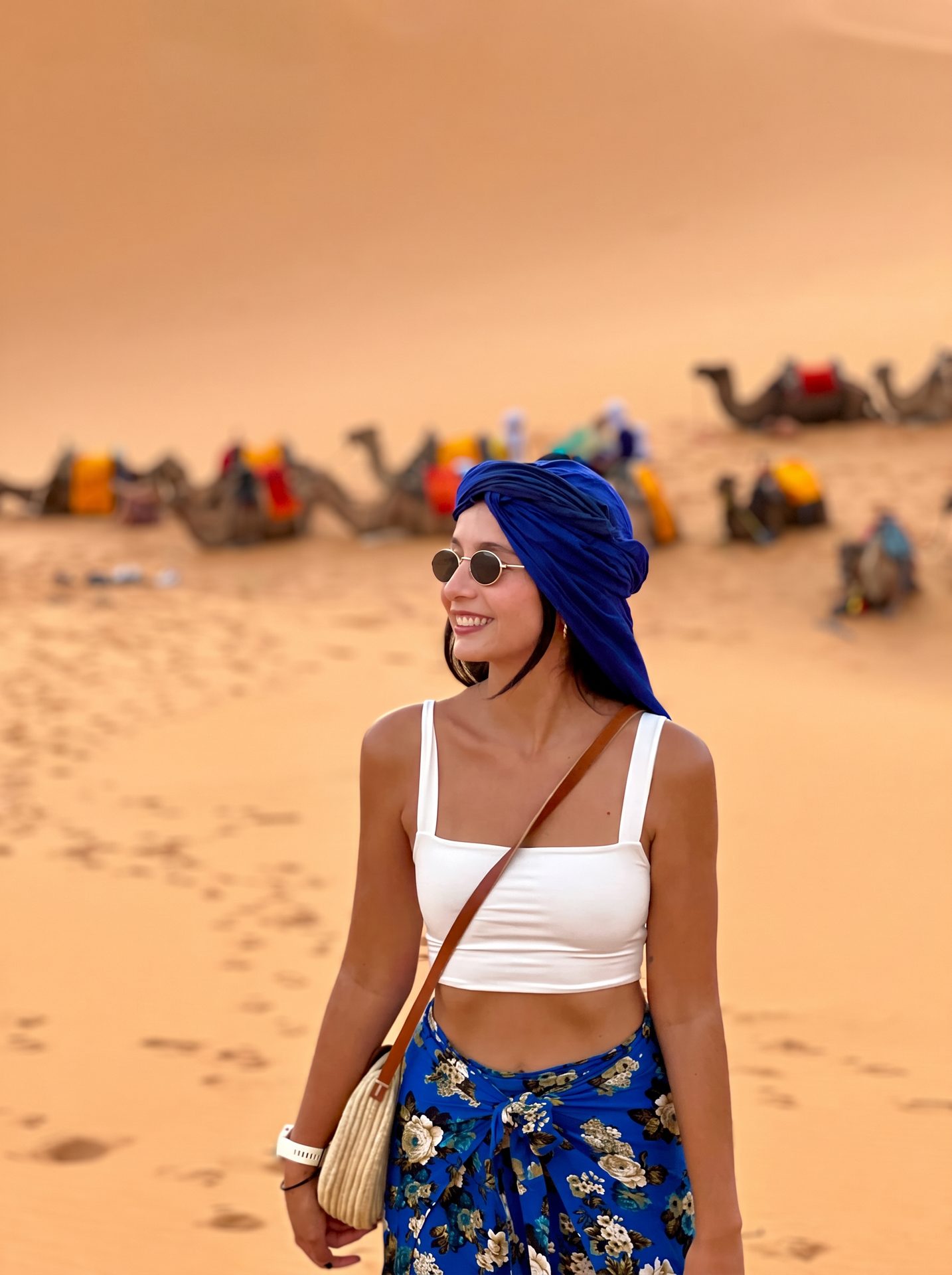 Viajera Weppa con turbante azul frente a los dromedarios del Sahara